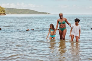 Eine Frau und zwei Kinder stehen im Wasser