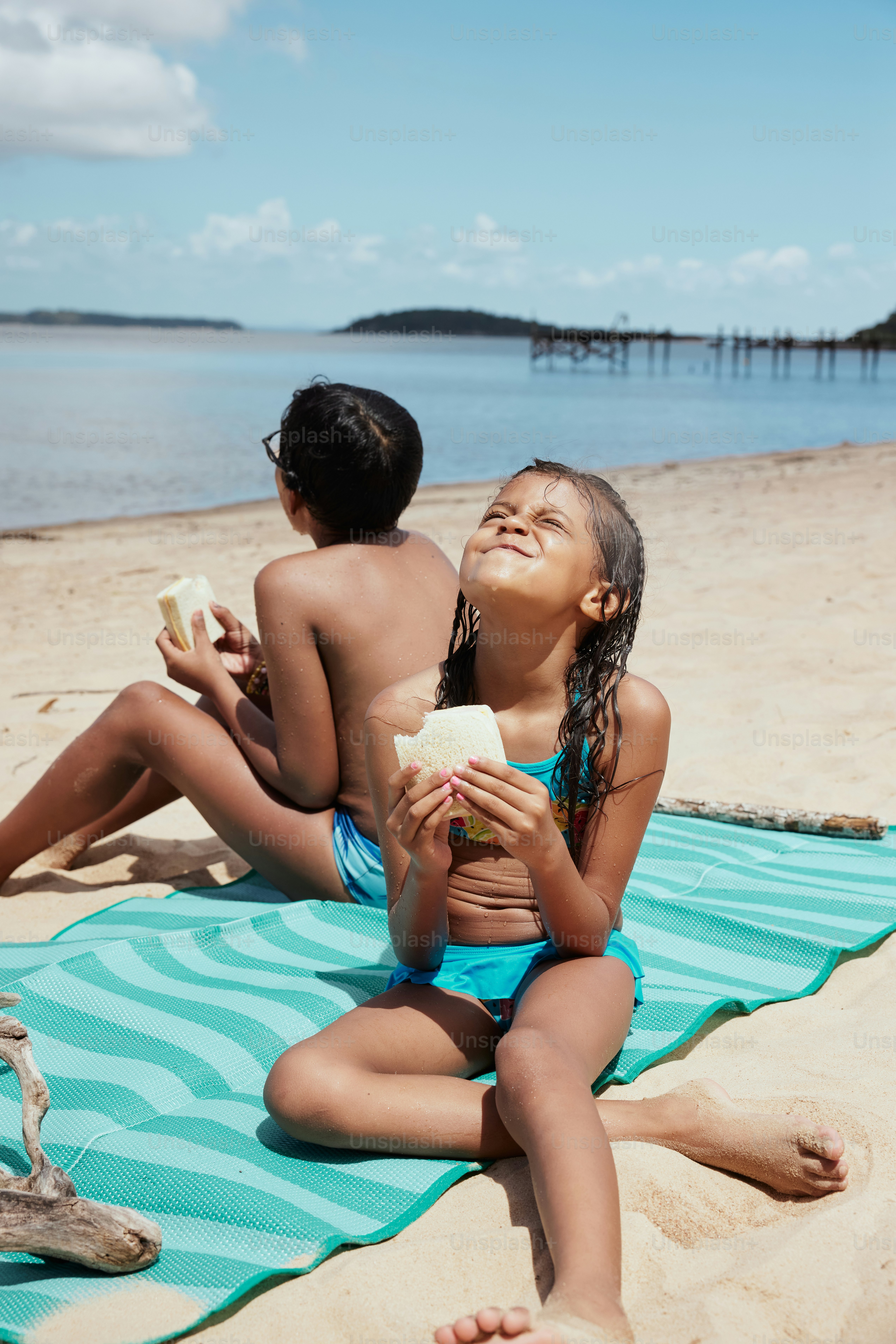 a couple of kids sitting on top of a beach