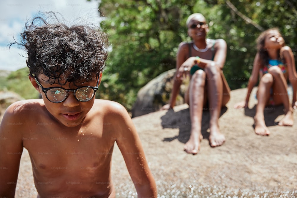 a couple of kids sitting on top of a dirt hill