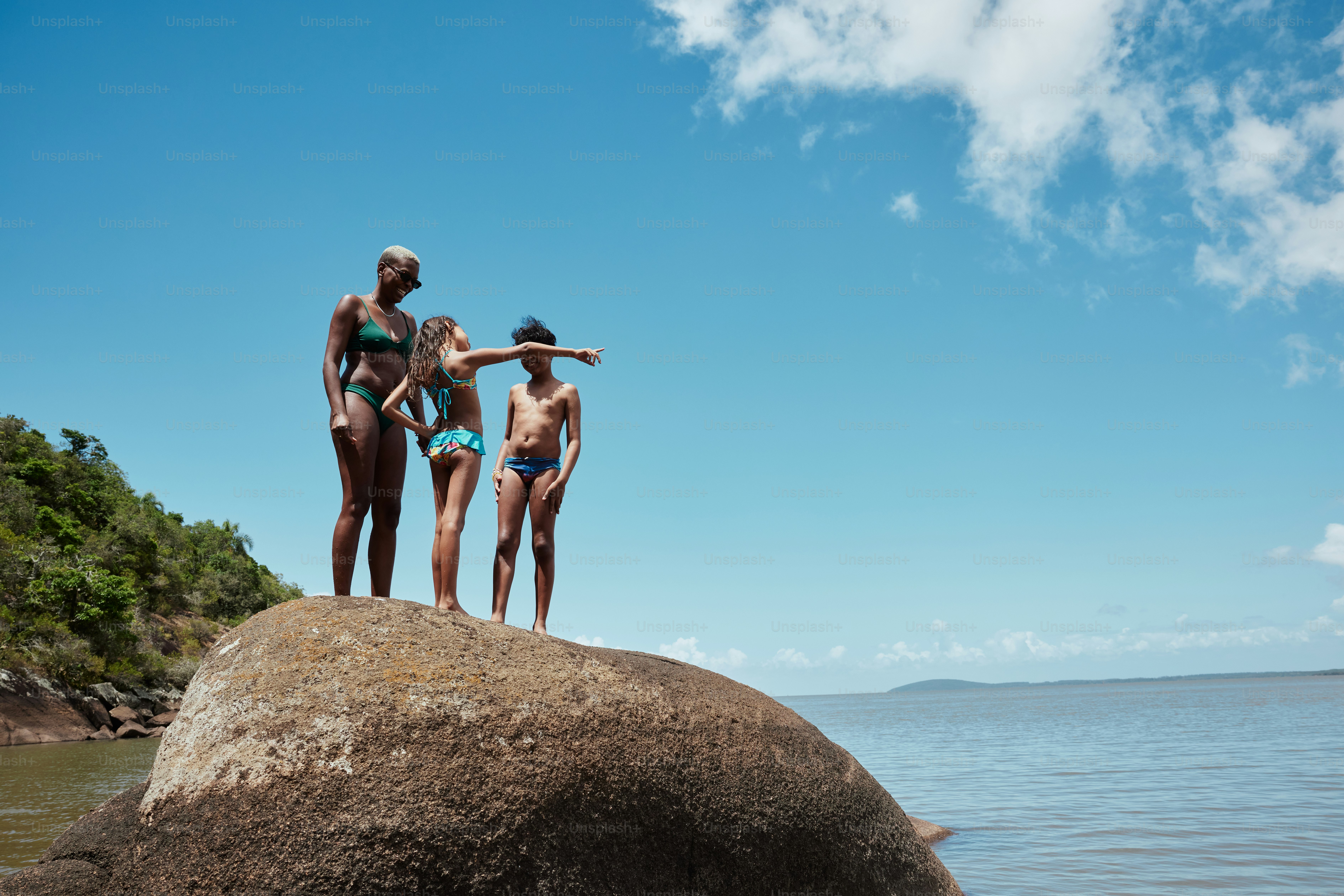 a group of people standing on top of a large rock