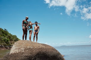 a group of people standing on top of a large rock