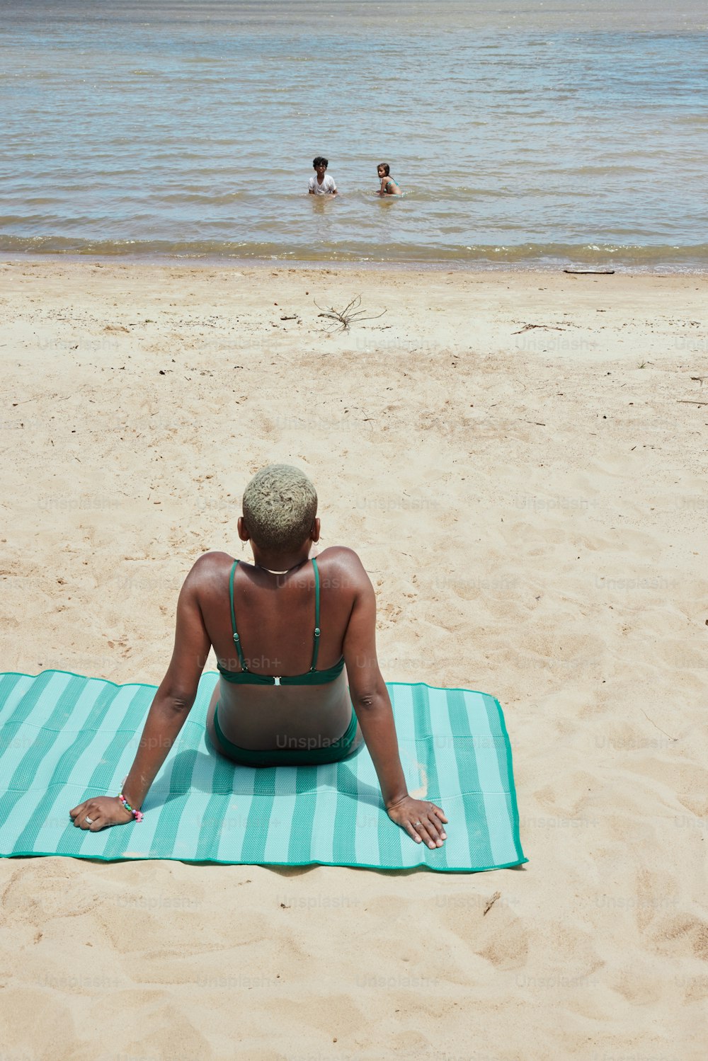 a person sitting on a towel on the beach
