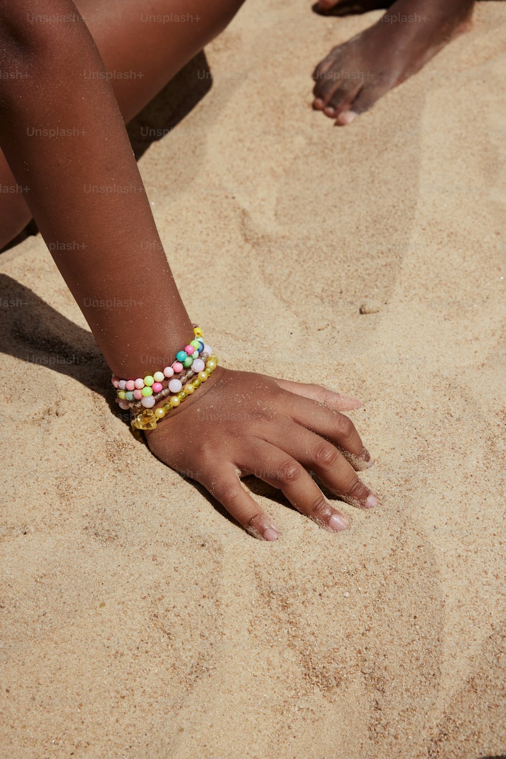 a close up of a person's hand on the sand