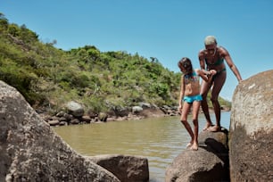 a man and a little girl standing on some rocks