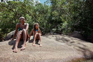 Ein Mann und ein kleines Mädchen sitzen auf einem Felsen