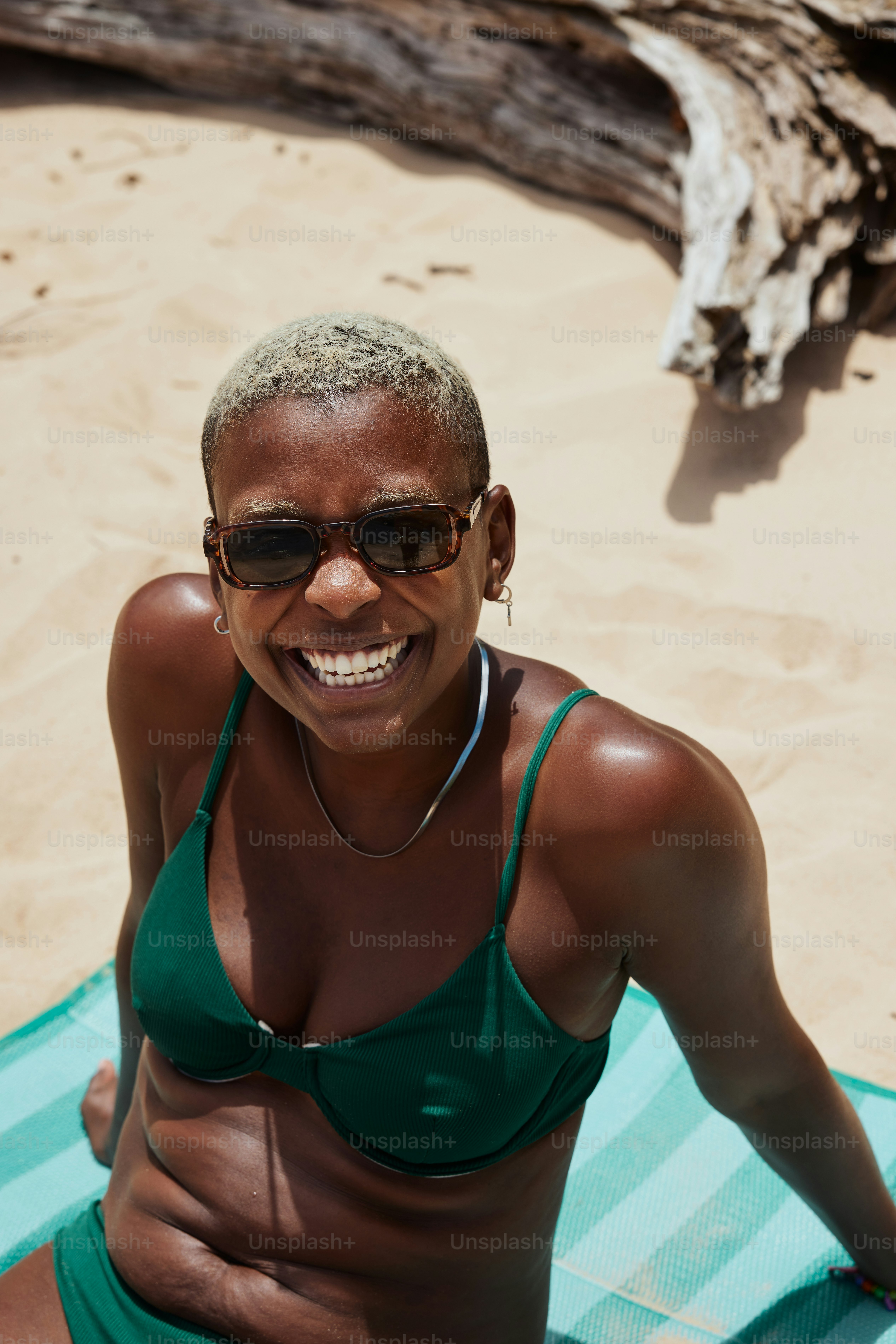 a woman sitting on a towel on the beach