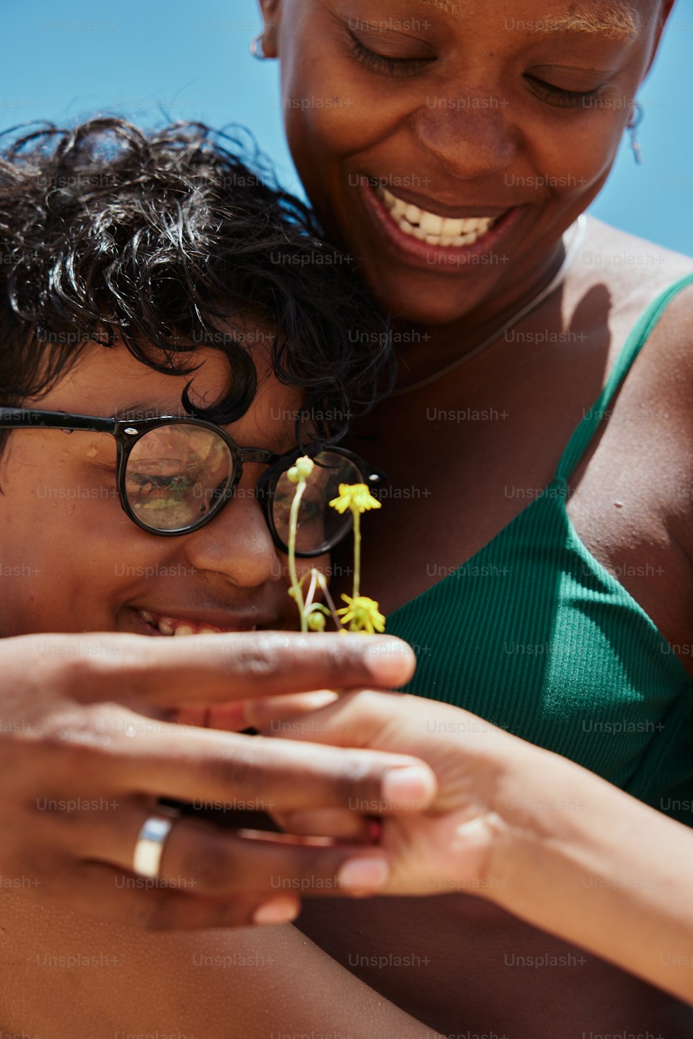 a woman and a child are looking at a plant