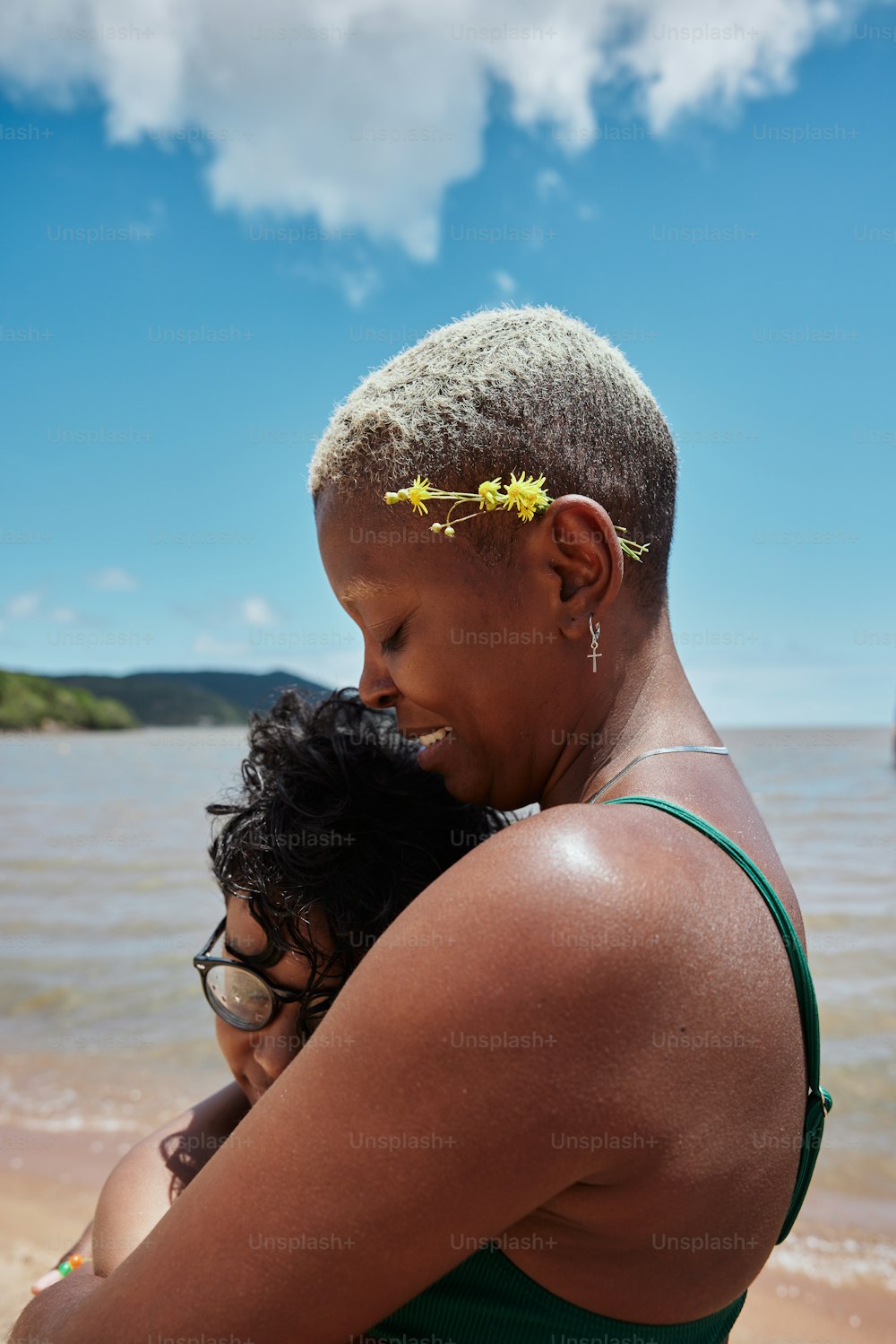 a woman holding a child on the beach