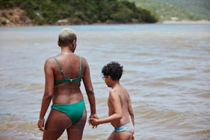 a woman and a boy are standing in the water