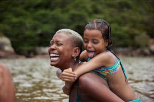 uma mulher segurando uma menina em seus braços