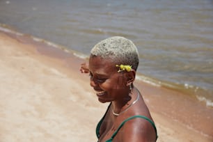 uma mulher com uma flor em seu cabelo na praia