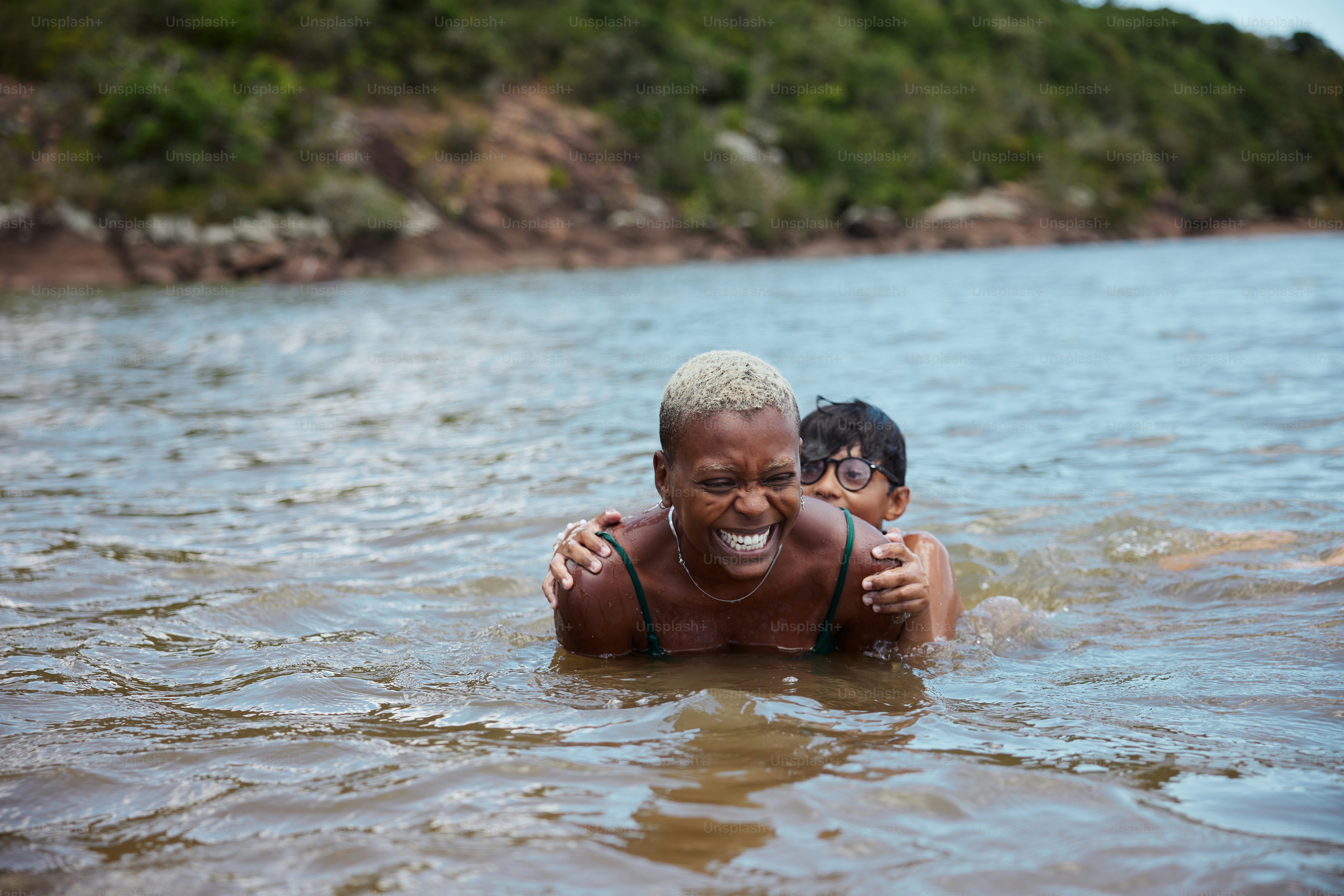 a woman and a boy are swimming in the water