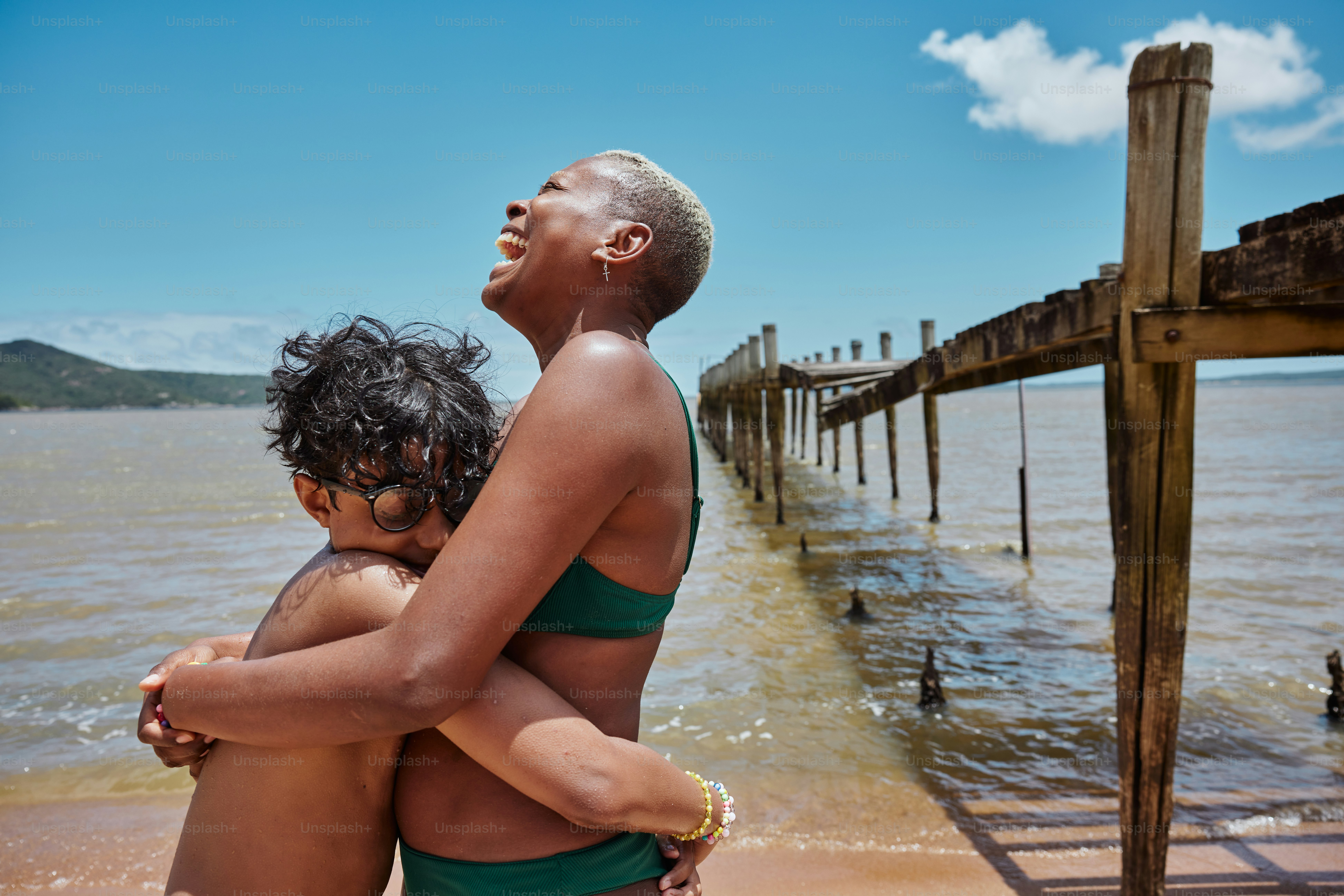 a woman in a green bathing suit holding a child