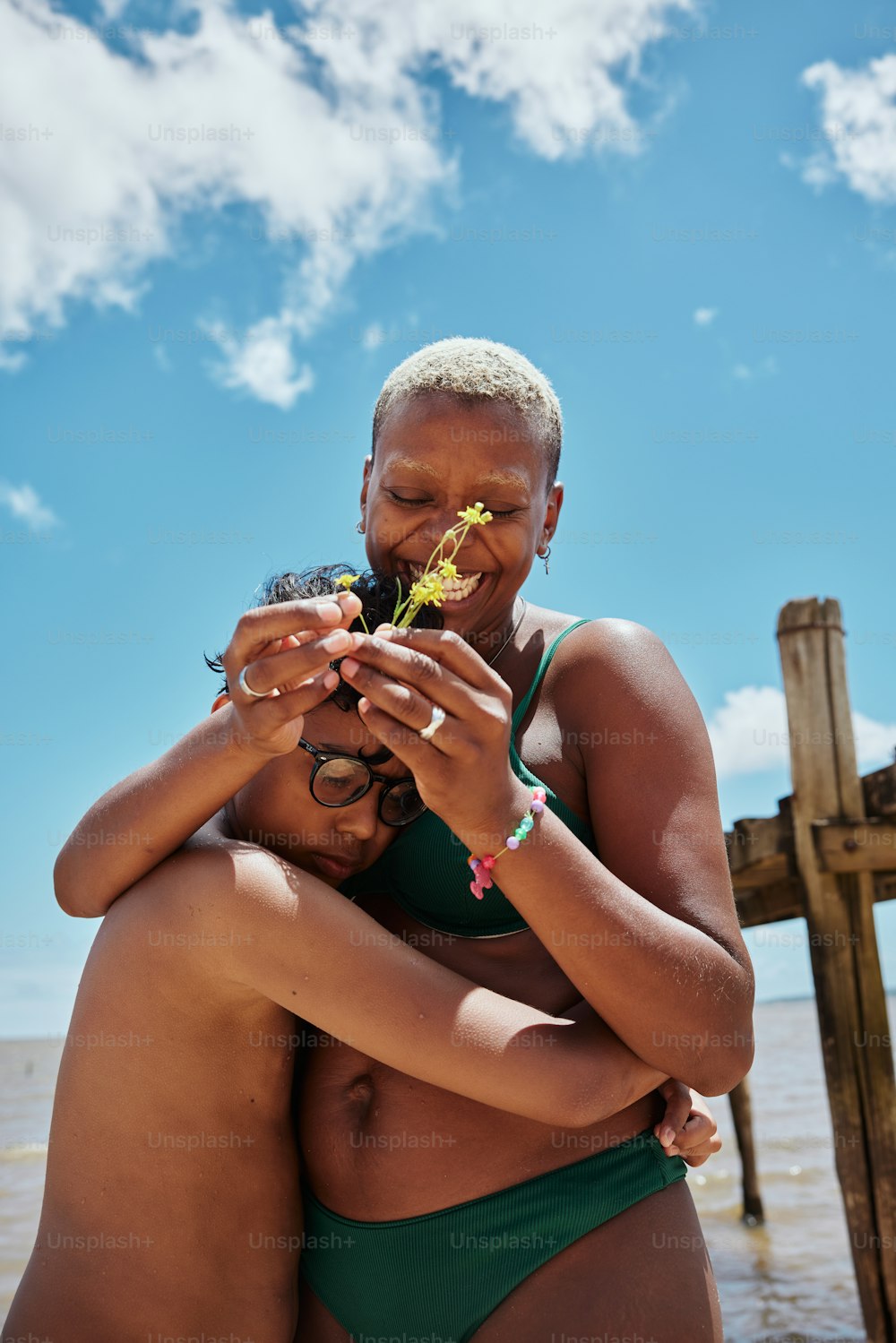 a woman in a green bikini holding a baby