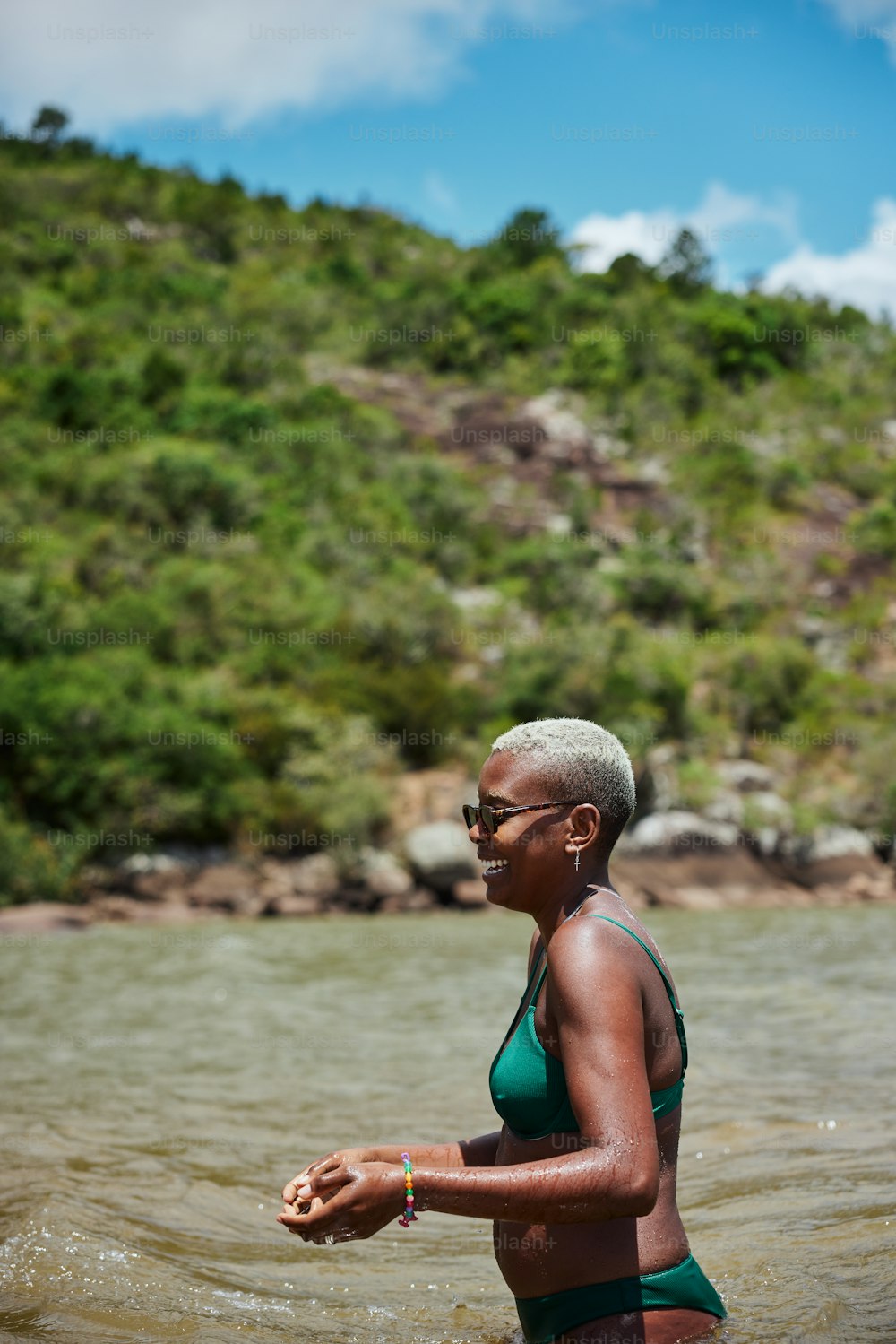 uma mulher em um maiô verde em pé na água
