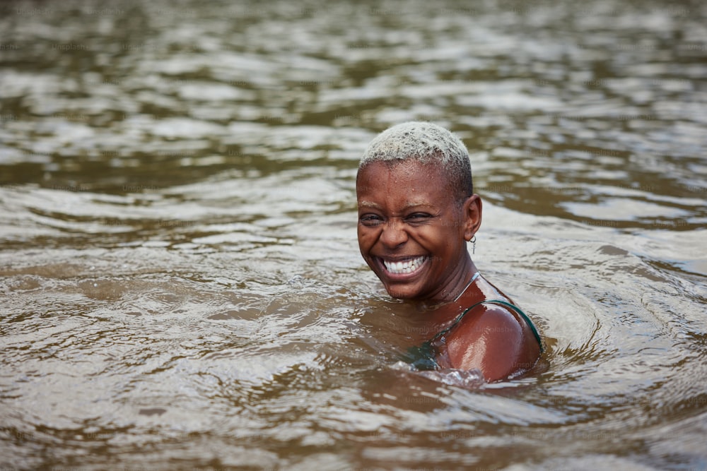 a woman in a body of water with a smile on her face