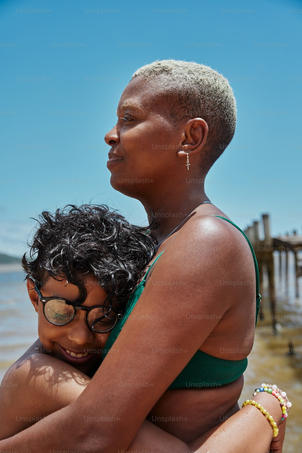 uma mulher que segura uma criança na praia