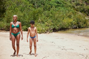 a woman and a child walking on a beach