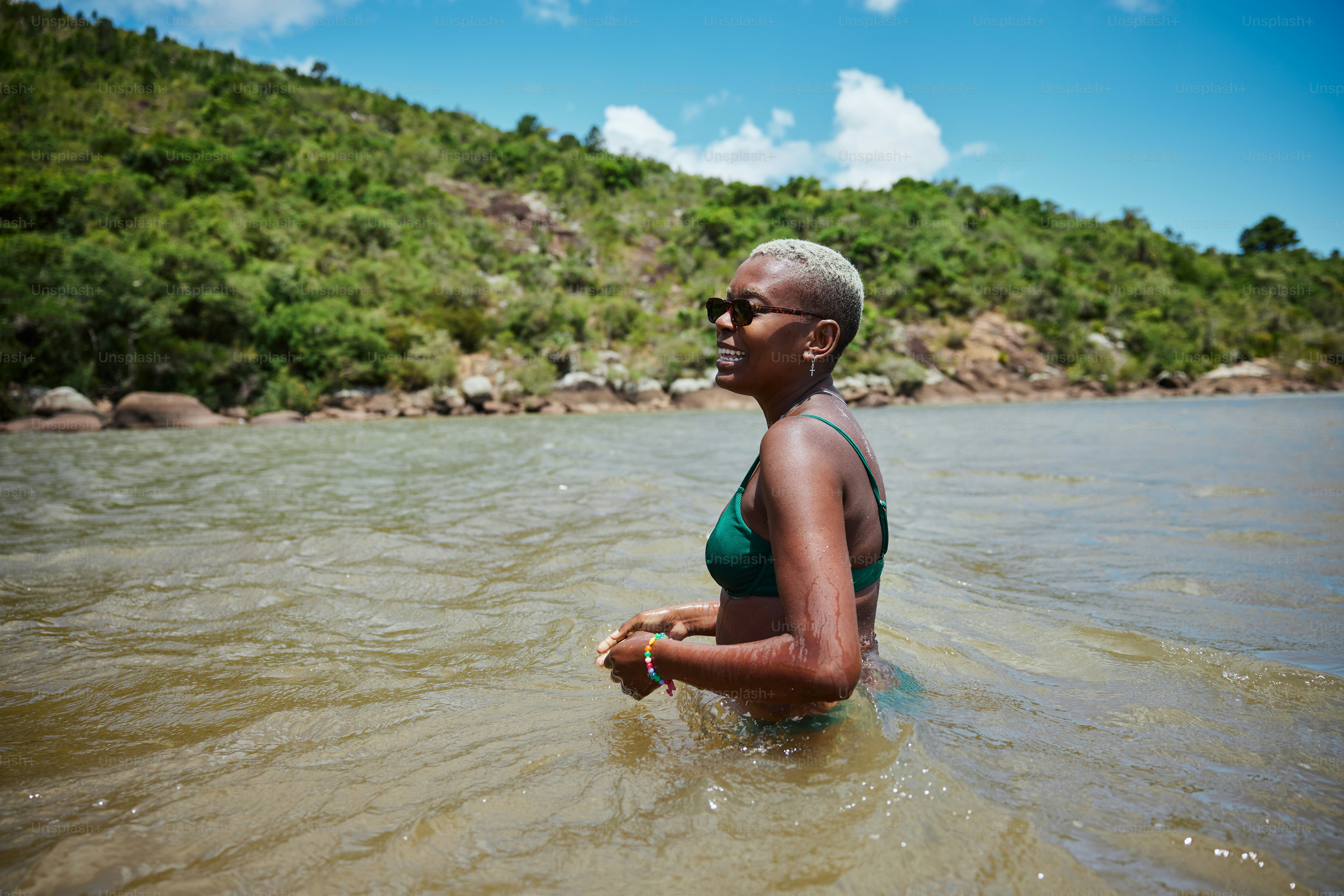 a woman in a green bikini wading in the water