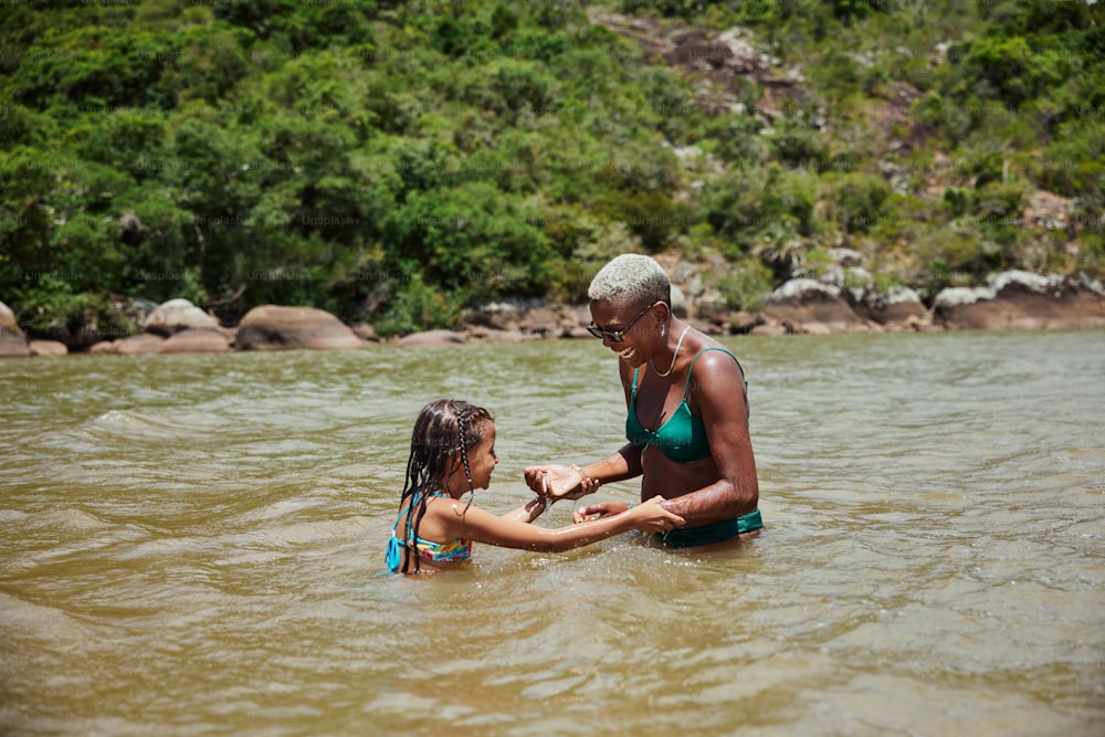 a woman and a little girl in a body of water
