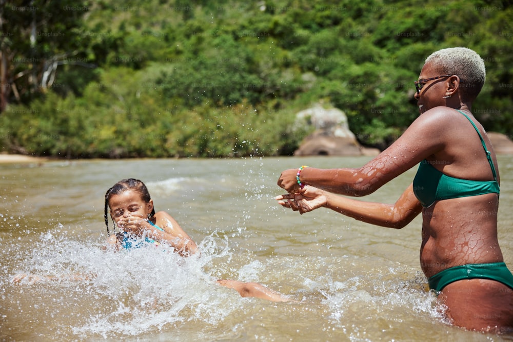 uma mulher e uma criança brincando na �água