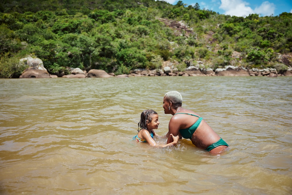 Una mujer y una niña jugando en el agua
