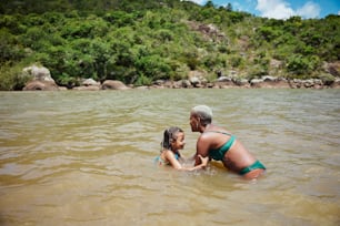 a woman and a little girl playing in the water