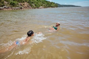 a couple of people swimming in a body of water