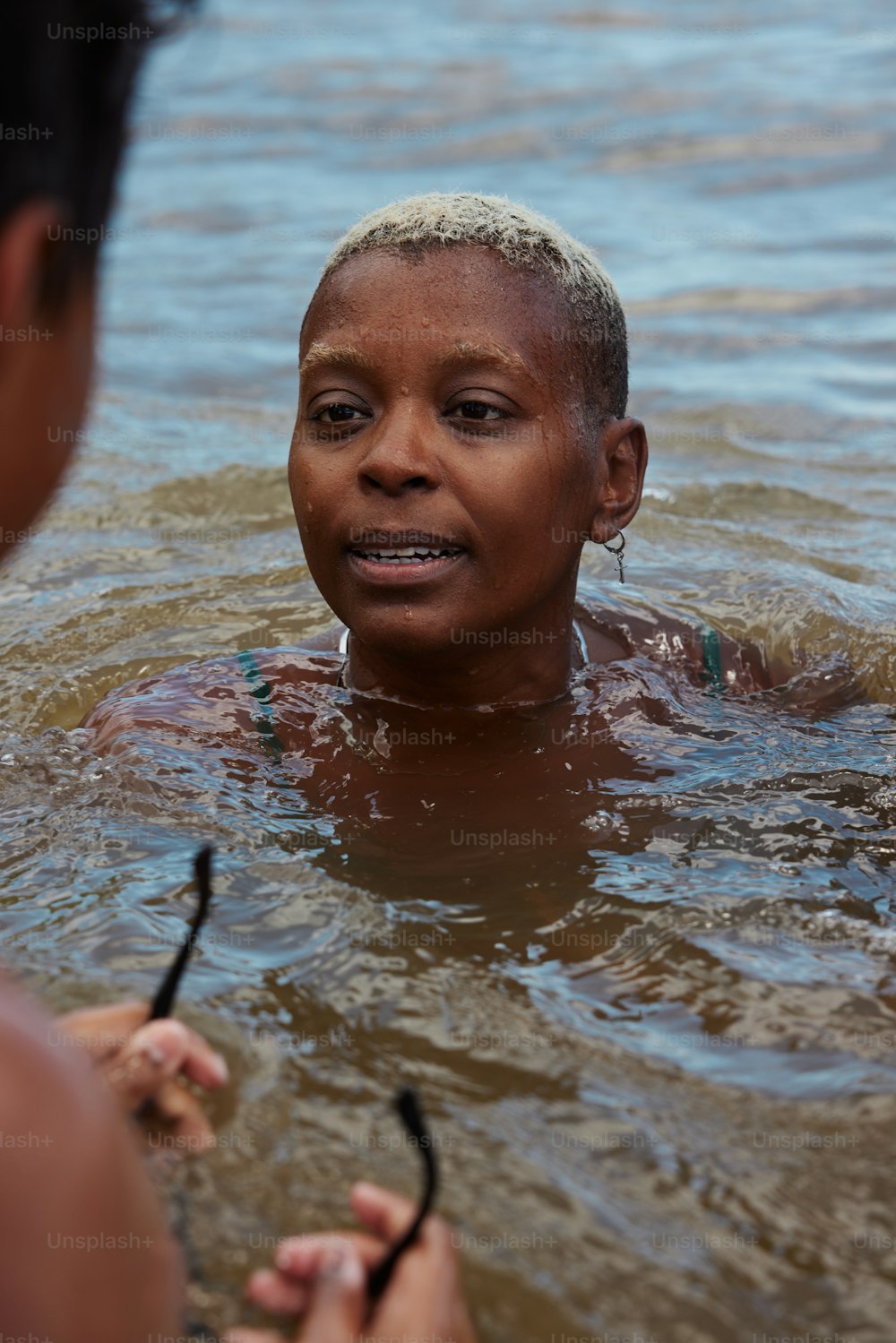 a woman in a body of water with a pair of scissors in her hand