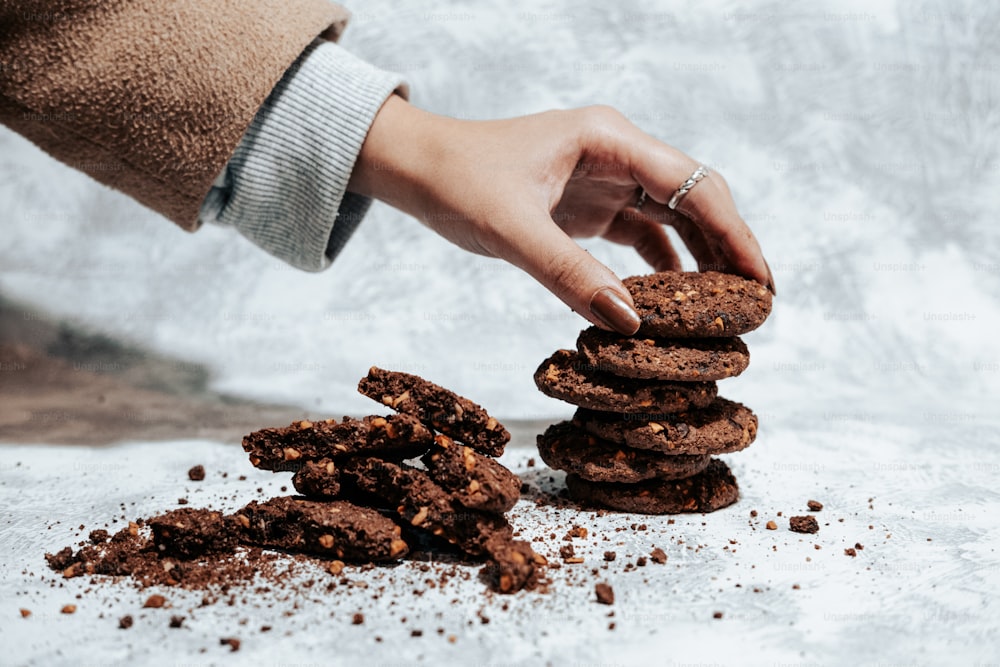 a person reaching for a stack of cookies