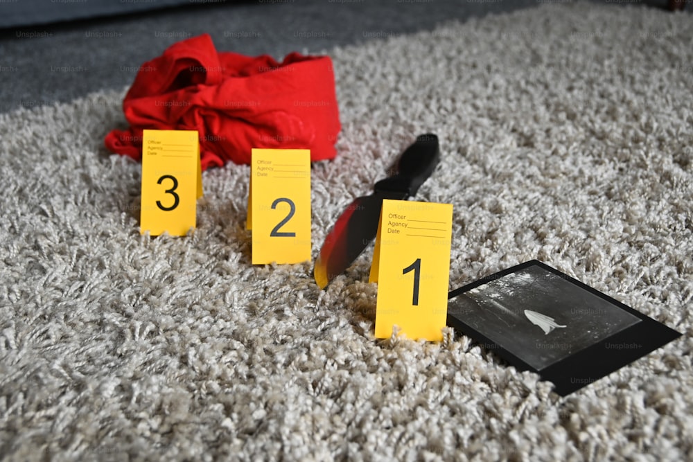 a number of yellow cards on a carpet with a red cloth