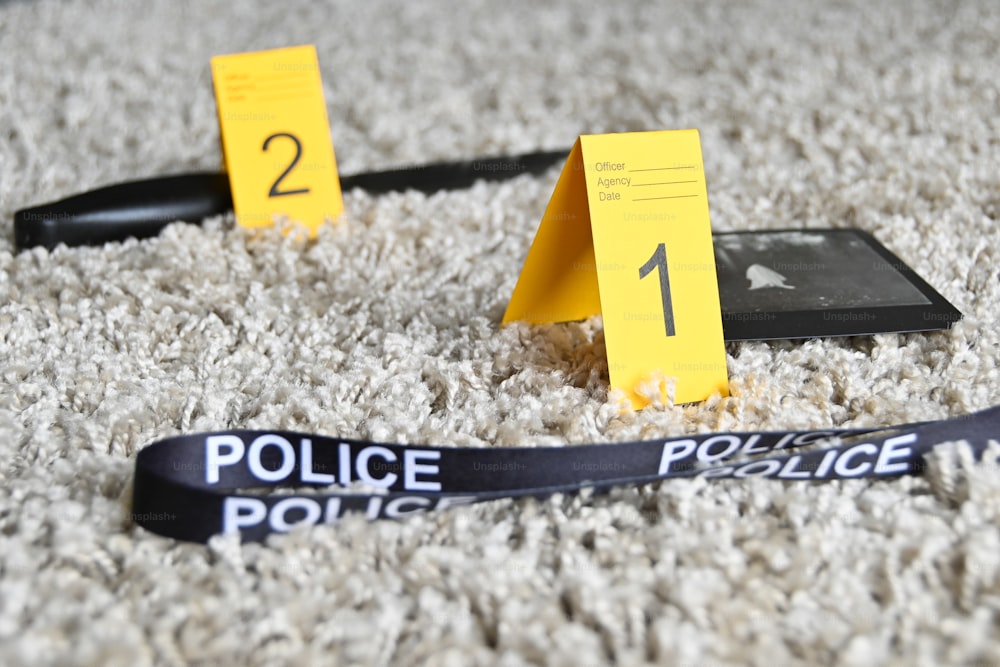 Un nastro della polizia posato sul pavimento accanto a un telefono cellulare