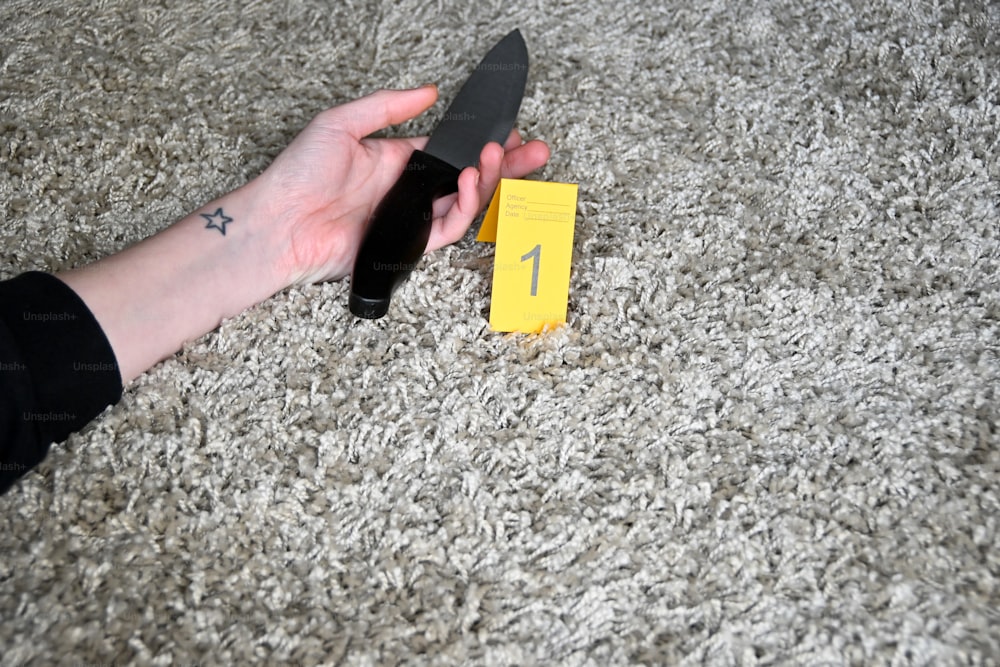 a person holding a knife on top of a carpet