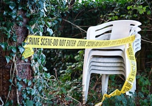 a stack of chairs sitting next to a yellow caution tape