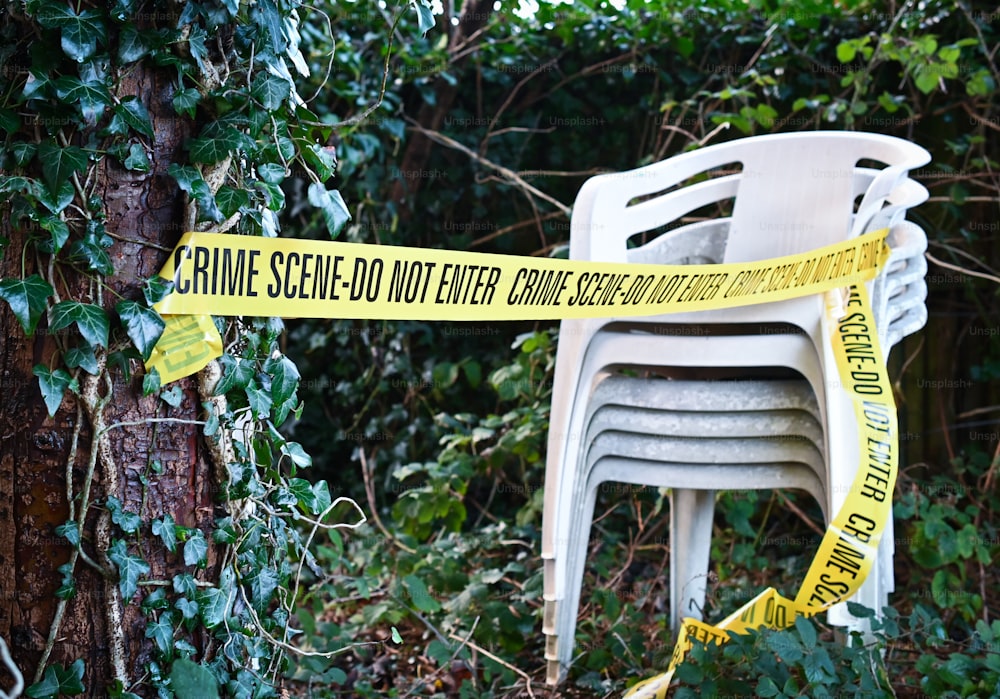 a stack of chairs sitting next to a yellow caution tape