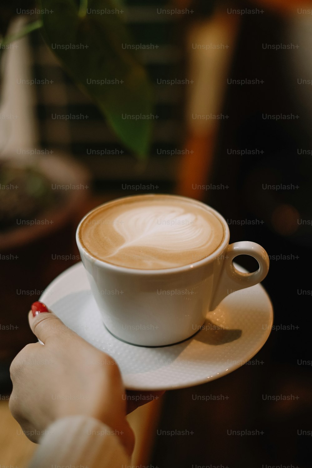 a person holding a cup of coffee on a saucer
