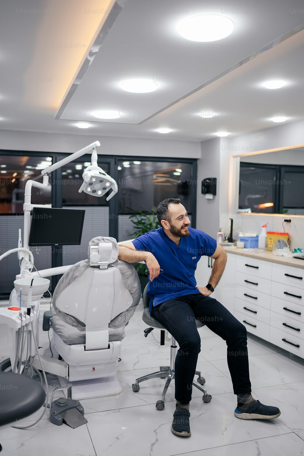 a man sitting on a chair in a dental room
