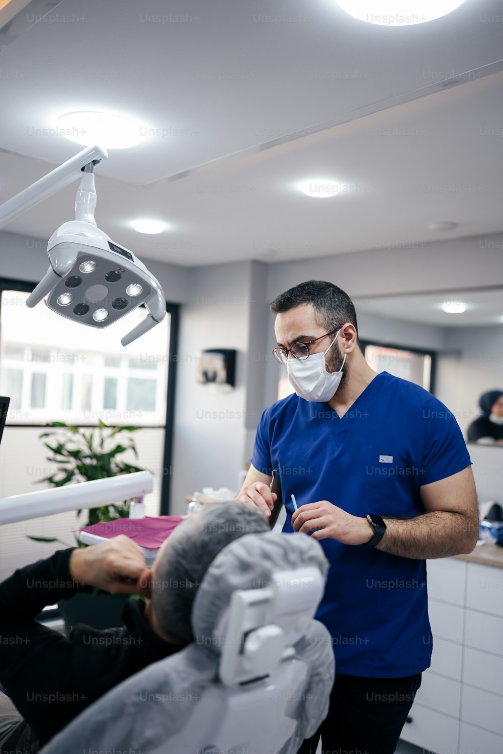 Un homme dans le cabinet d’un dentiste portant un masque facial