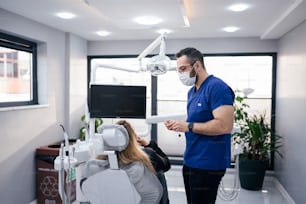a man standing next to a woman in a dentist's office