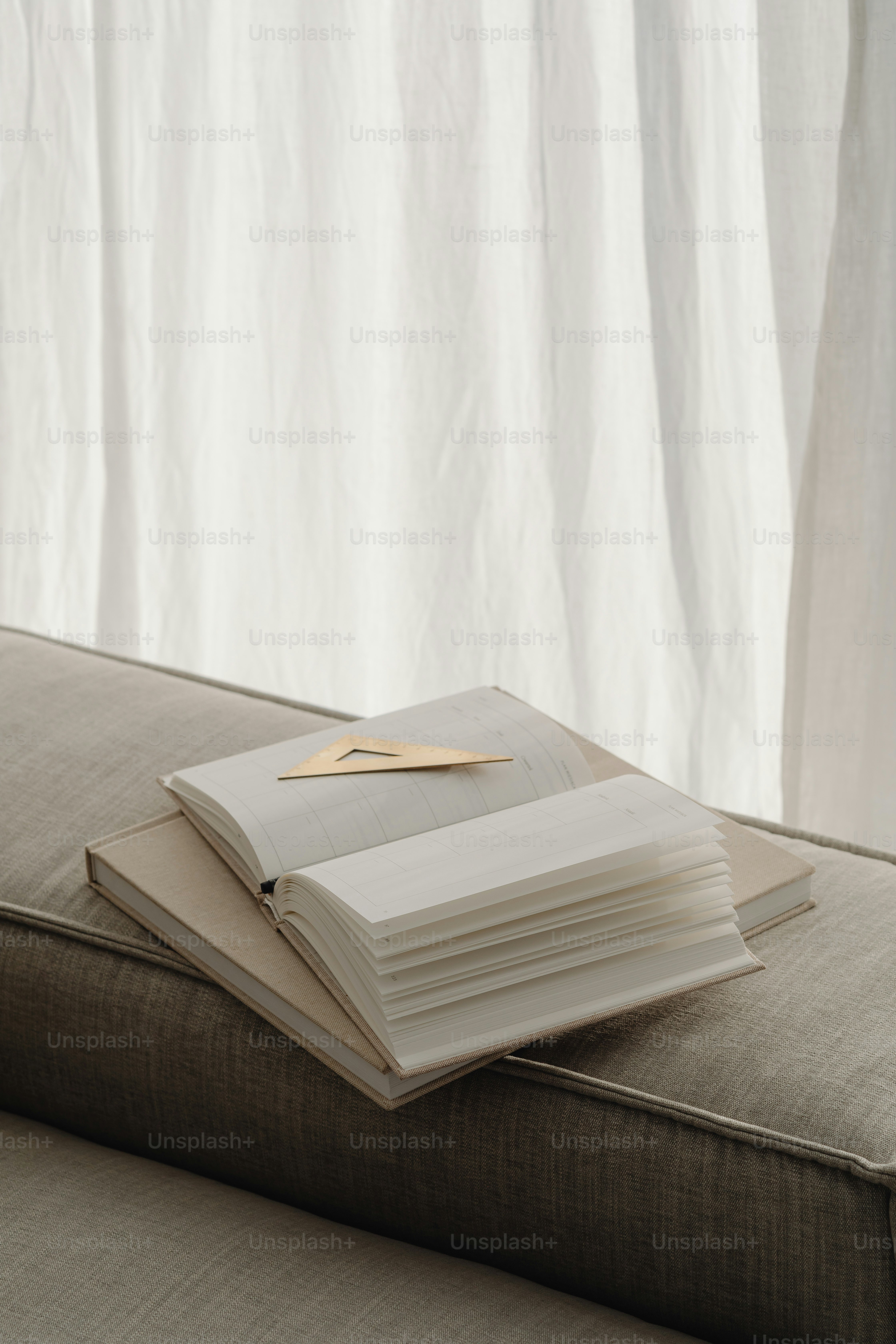 a stack of books sitting on top of a couch
