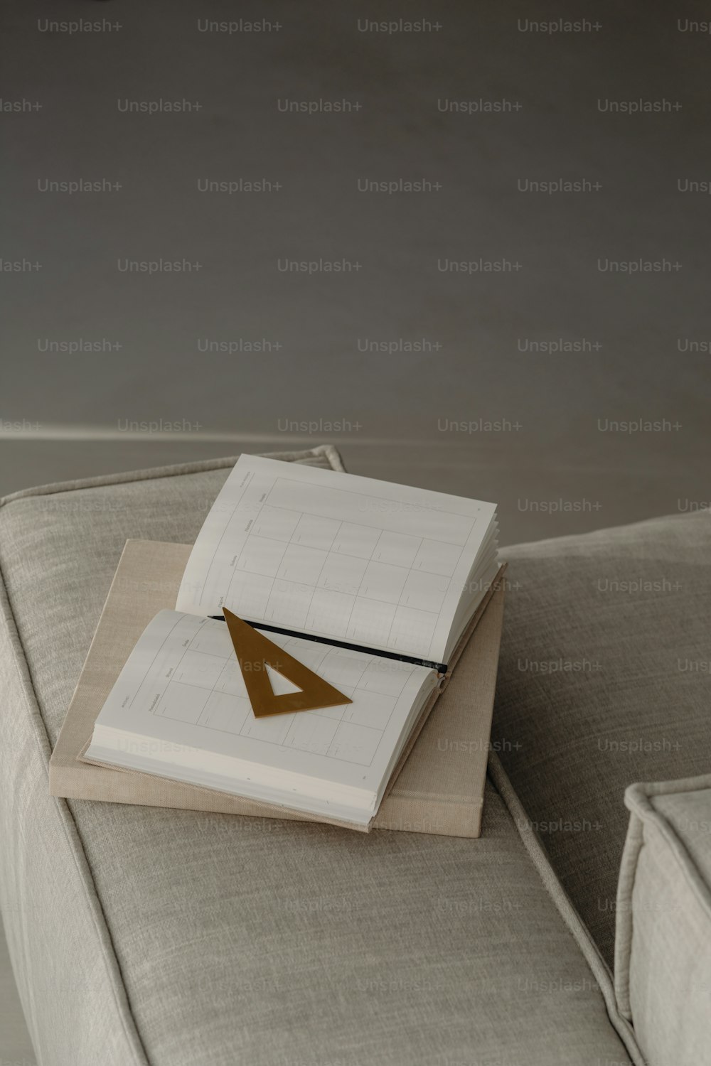 a stack of books sitting on top of a couch