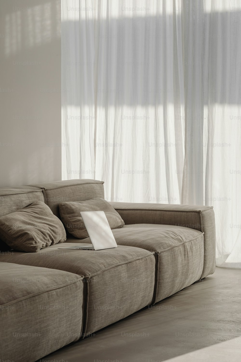 um sofá sentado em frente a uma janela com uma folha de papel sobre ele