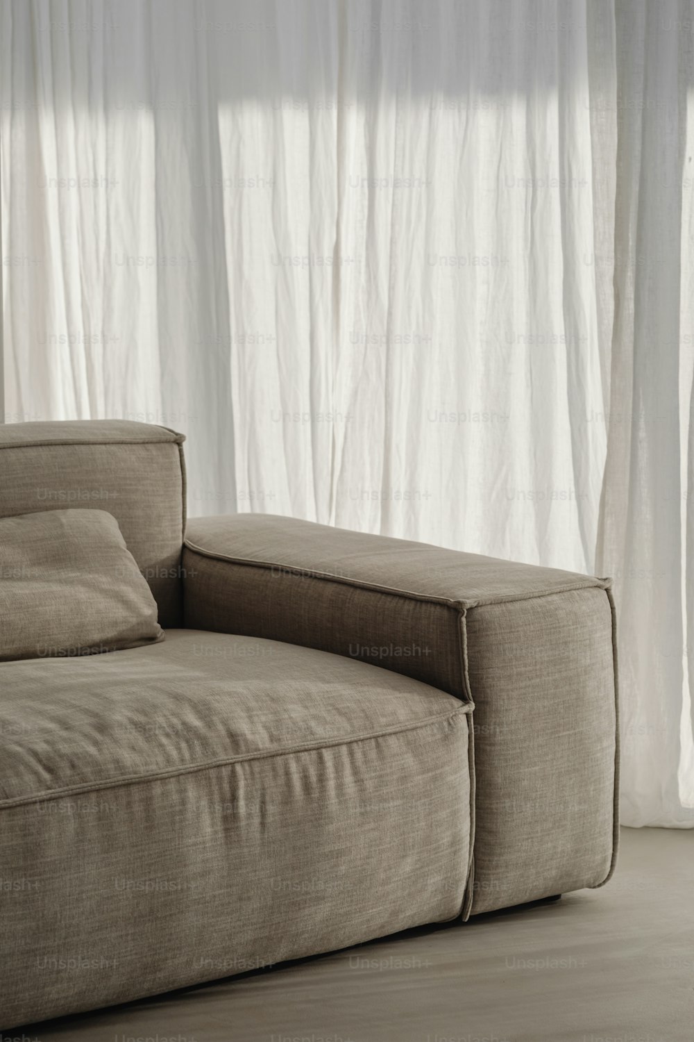 a beige couch sitting in front of a window