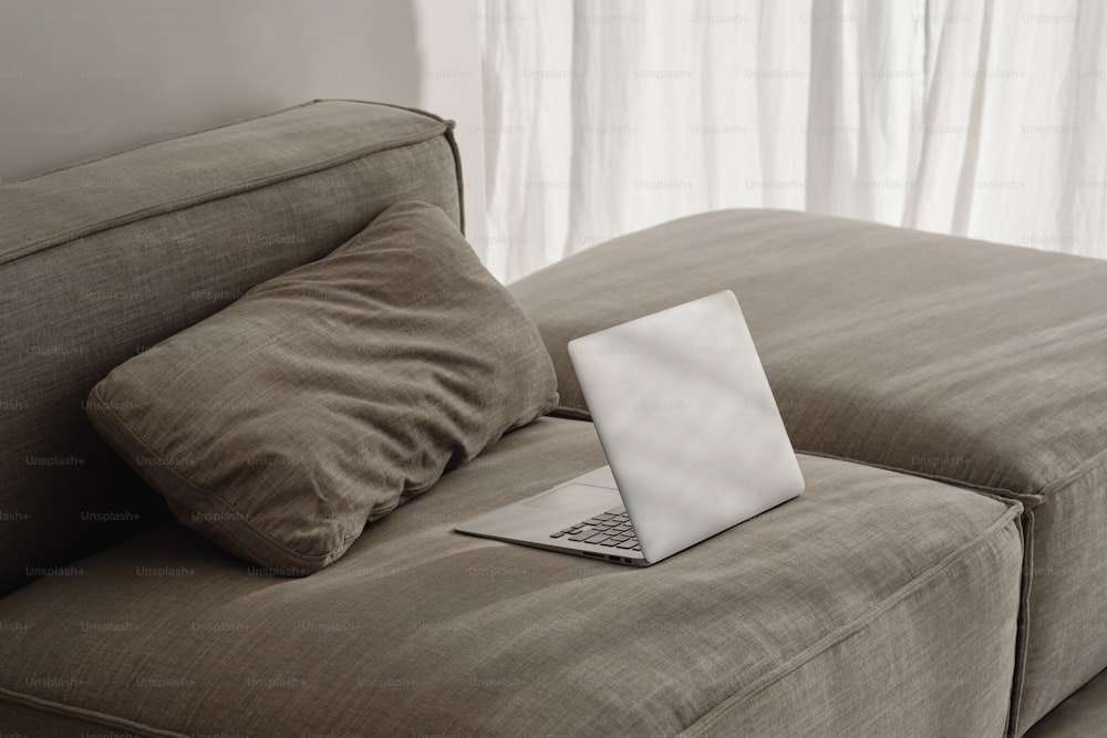 a laptop computer sitting on top of a couch