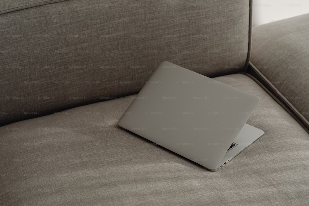 una computadora portátil sentada encima de un sofá