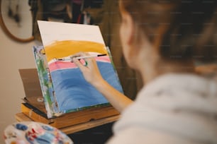 Una donna sta dipingendo un quadro su un cavalletto