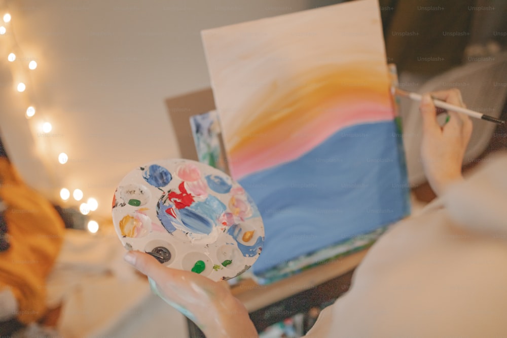 Una mujer está pintando un cuadro en un lienzo