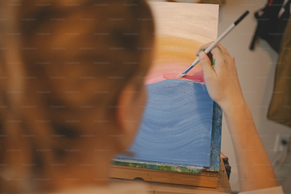 Une femme peint un tableau sur une toile