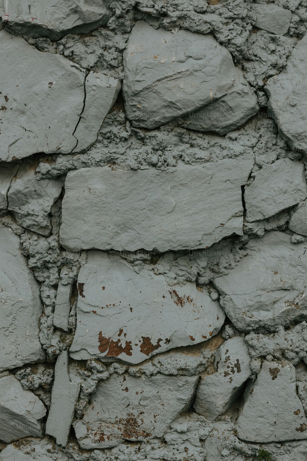 a close up of a stone wall with a clock on it