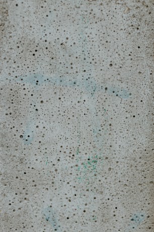 a cement surface with green dots on it